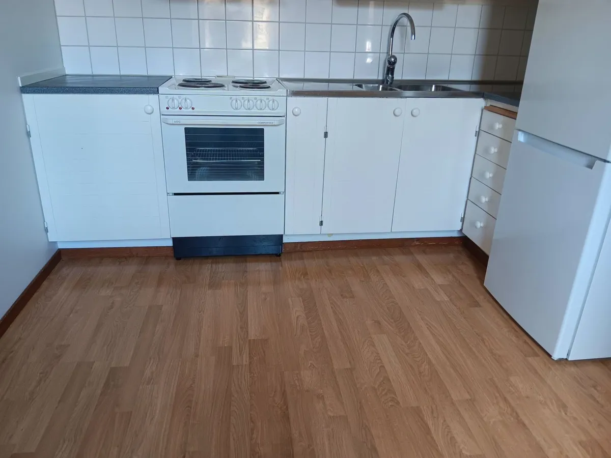 Kök med vita luckor och trägolv efter städning